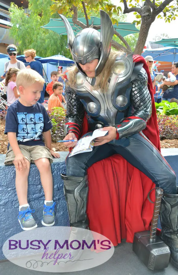 No more boring lines at Disneyland - grab our 2016 'Unofficial' Disneyland Activity & Autograph book to keep the kids happily entertained! Thor playing games in our activity book with boy at Disneyland