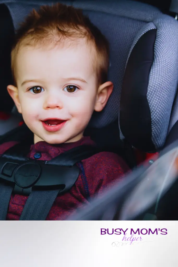 photo of a child in a carseat on a gray background 