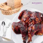 photo of a bbq roasted chicken on a white plate and a marble background.