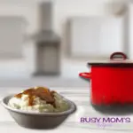 Photo of mashed potatoes in a white bowl with brown gravy